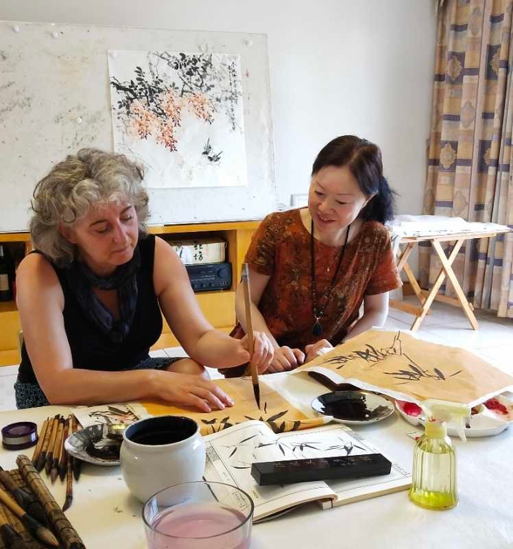 Genny learning to paint bamboo with Wang Xiao Yan in her home