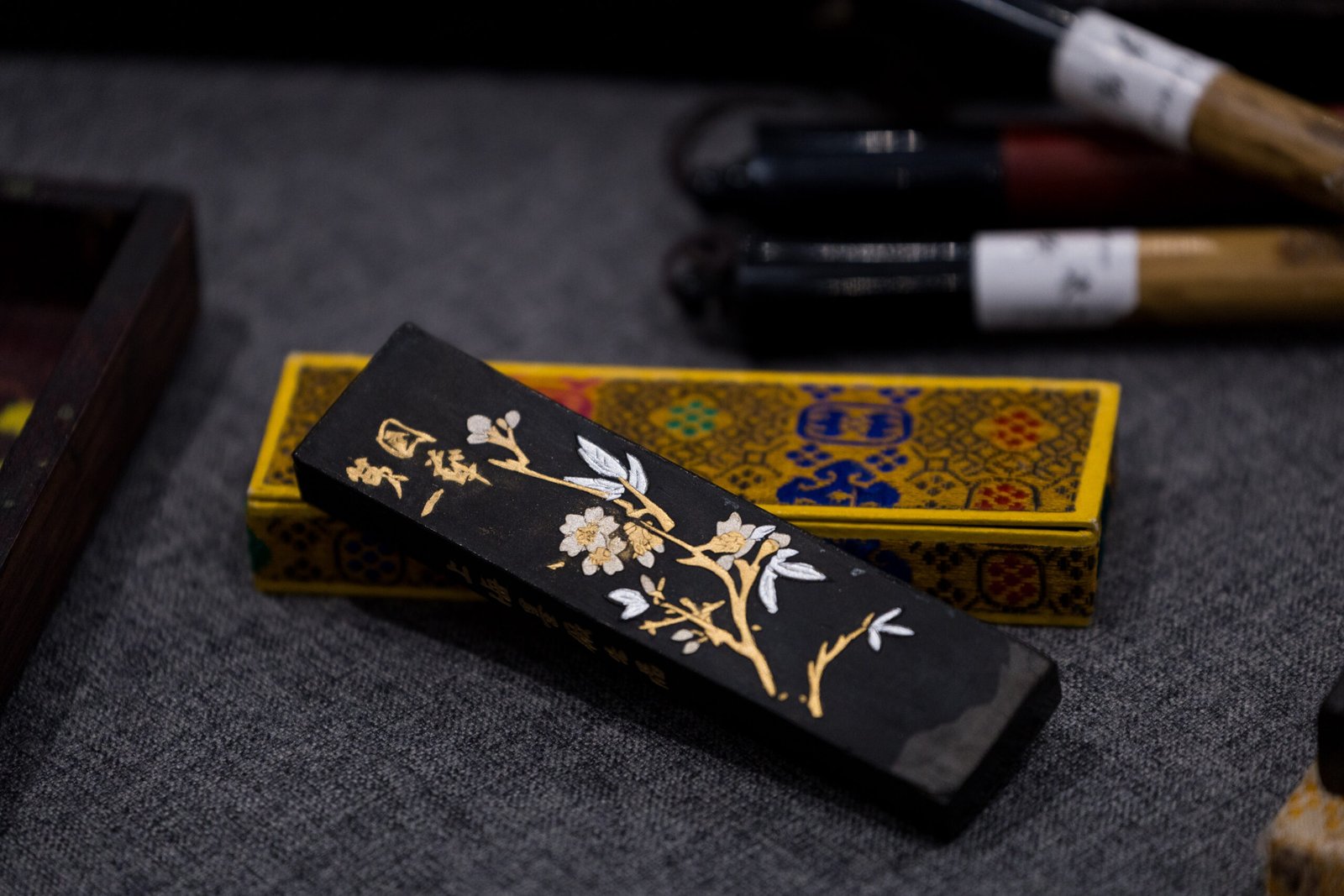 A Chinese ink stick decorated with a flower design in white and gold