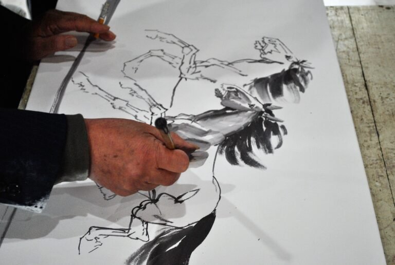 A right-handed male Chinese artist painting a horse onto porcelain. A close-up of this hand as he paints.