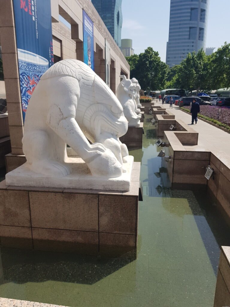 The white carved stone lions standing along the front of Shanghai Museum, May 2019