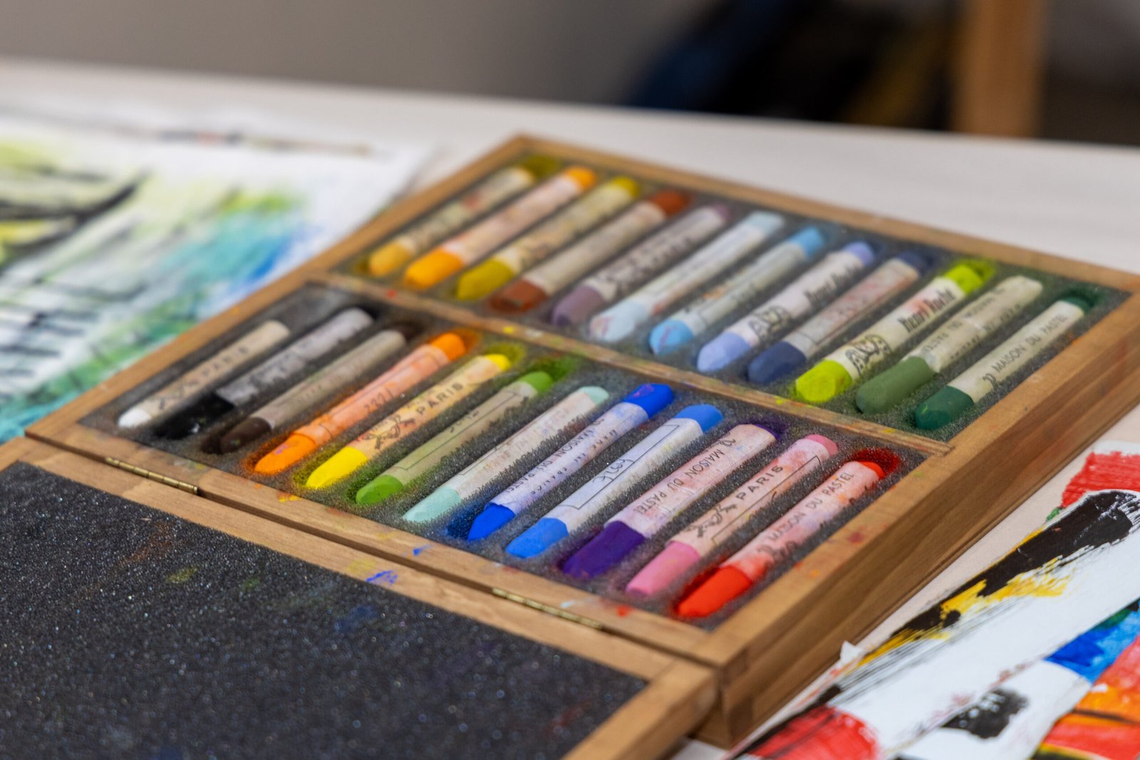 A wooden box filled with 24 brightly-coloured pastels made by La Maison du Pastel in Paris
