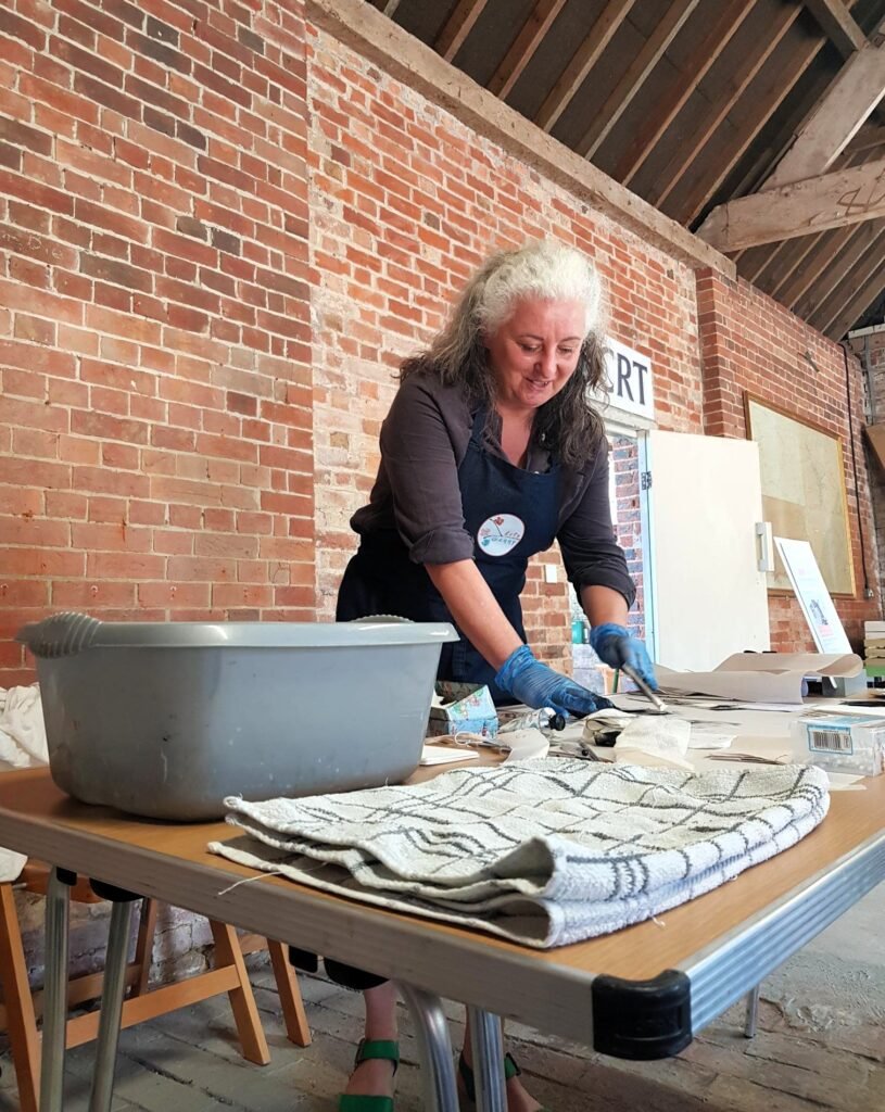 Arty Genny giving a printmaking demonstration, inking a Tetra Pak printing plate
