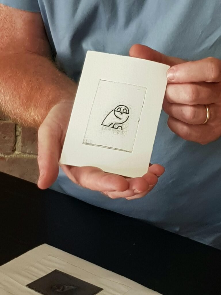 A man proudly holding his hand-inked Tetra Pak print of an owl logo belonging to Sheffield Wednesday Football Club